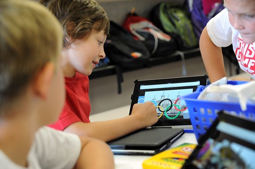 Fifth grader Ryan Foster, 10, uses an Apple iPad to research Olympic competitions Aug. 10, during Olympic Day at Ridgeview Elementary School in Colorado Springs. During summer break, Falcon School District 49’s Board of Education approved a three-year lease for 250 iPads in the POWER Zone, where educators are studying the feasibility and value in a one-to-one district distribution plan.