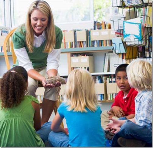 Kindergarten teacher and children looking at bird's nest in library